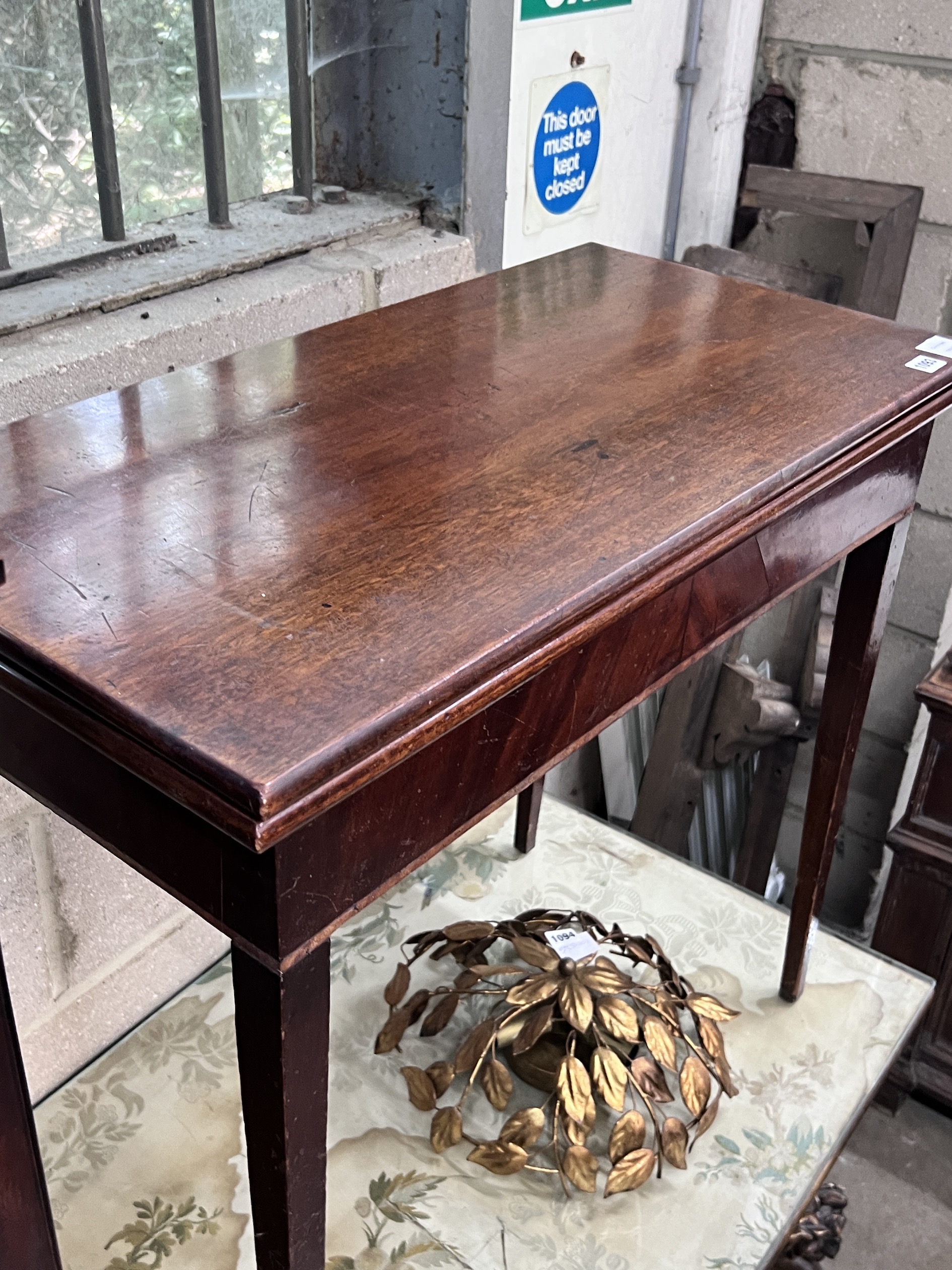 A small George III glazed mahogany hanging cupboard, height 85cm and a George III mahogany rectangular folding card table, width 80cm, depth 40cm, height 73cm (2)